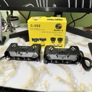 High-performance electric motorcycle foot pegs displayed on a marble surface with a yellow Spec's box in the background, highlighting innovative ride India Ride electric vehicle accessories.